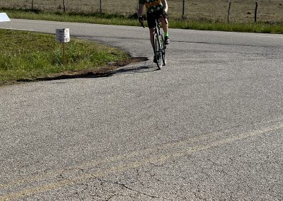 Cyclist riding on rural road during Bluebonnet Express, enjoying scenic Texas bike routes.