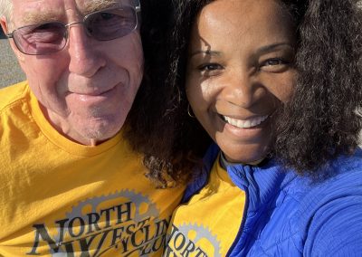 Smiling volunteers in bright yellow and blue shirts at Bluebonnet Express charity bike event.
