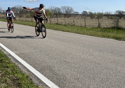 Vivid image of cyclists riding on open road through Texas Bluebonnet country, enjoying scenic spring outdoor biking adventure.