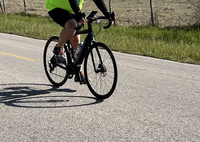 Bright yellow cycling safety vest during Bluebonnet Express ride, in open countryside on a sunny day.
