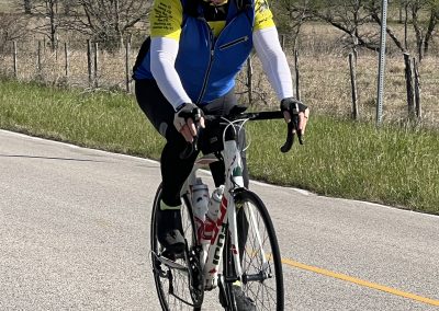 Cyclist riding on scenic country road, promoting Bluebonnet Express bike tour and outdoor cycling adventures.
