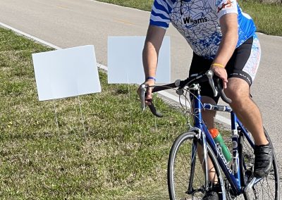 Cyclist riding along a rural road during Bluebonnet Express event, enjoying scenic Texas countryside.