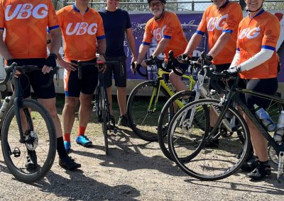 Cycling team wearing UBG jerseys at Bluebonnet Express event, ready for road ride.