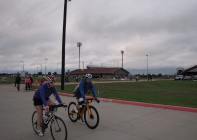 Bluebonnet Express cycling event at Texas sports complex, featuring cyclists riding on a cloudy day.