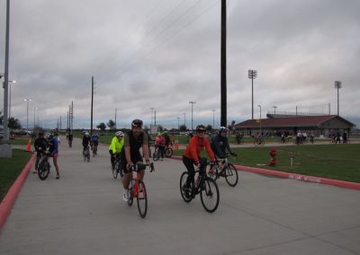 Group of cyclists riding on a bike trail under cloudy skies at Bluebonnet Express event.