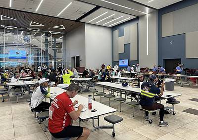 Freshly fed cyclists dining at Bluebonnet Express indoor meal area, fueling up after ride. Modern, spacious, and bright sports venue for athletes.