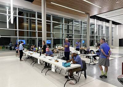 Innovative indoor cycling event at Bluebonnet Express with participants registering and preparing for a cycling race.