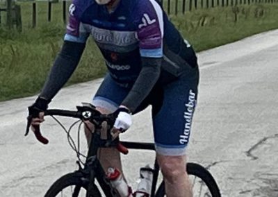 High-performance bicycle rider on a gravel road, capturing the essence of Bluebonnet Express cycling.