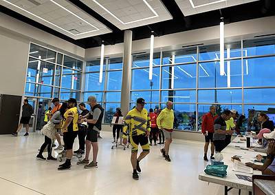 Bright indoor cycling event with participants checking in, showcasing active lifestyle and cycling gear.