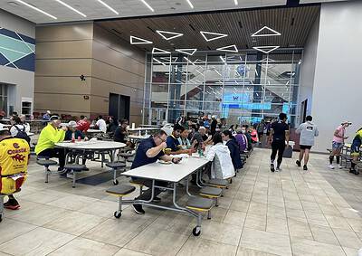 Bright indoor eating area at Bluebonnet Express food court with cyclists and travelers dining.