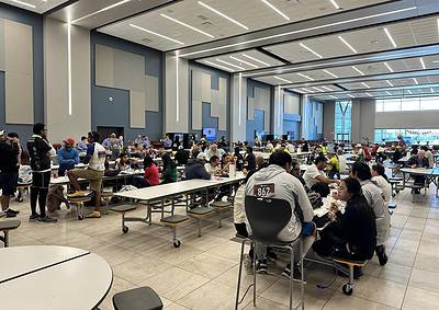 Bright, modern dining hall filled with diverse people enjoying meals and socializing at Longhorn Steakhouse.