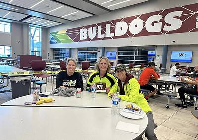 Comfortable runners enjoying a meal at the Bluebonnet Express event inside a modern sports facility.