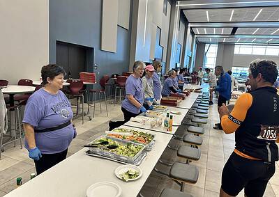 Volunteers serving food at Bluebonnet Express charity event in a modern, spacious indoor venue.