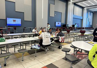 Colorful indoor sports arena with spectators and team members, high-tech screens, and seating arrangements.