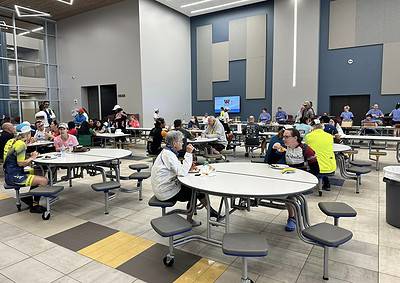 Bright indoor dining area at Bluebonnet Express, with cyclists and travelers enjoying meals.