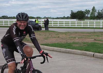Happy cyclist riding with Bluebonnet Express bike, smiling during a sunny outdoor event.