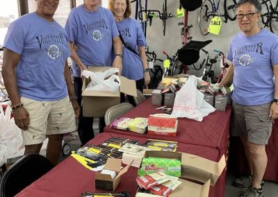 Volunteers at Bluebonnet Express bike shop organizing bike accessories and merchandise for community sale.