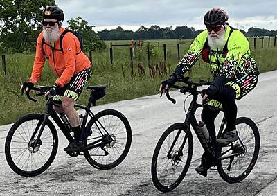 Adventure cycling with riders in colorful gear on scenic rural road.