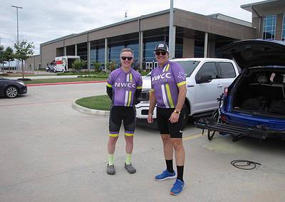 Cyclists in purple NWCC Houston jerseys standing outside after a ride, with bikes loaded in a vehicle.
