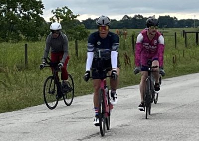 Vibrant cyclists riding on rural road, Bluebonnet Express, Texas biking event, outdoor fitness, cycling adventure.