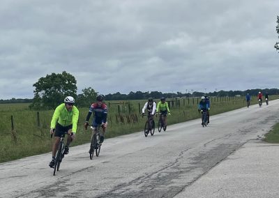 Cyclists riding on a rural road near Bluebonnet Express, enjoying scenic Texas bicycle tours.
