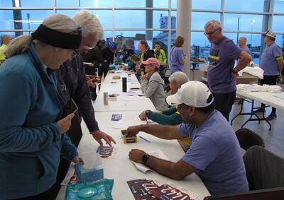 People registering for a cycling event at Bluebonnet Express, an organized bike race in a modern indoor venue.