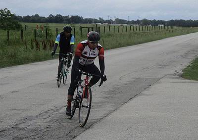 Cyclists riding on a rural road during daytime, showcasing Bluebonnet Express cycling event.