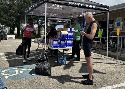 Cycling event booth at Bluebonnet Express with people purchasing snacks and drinks.