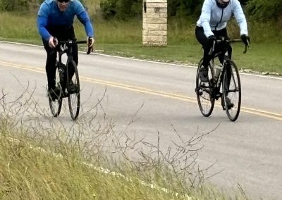 Riders enjoying scenic Texas countryside on bicycles with Bluebonnet Express cycling event theme.
