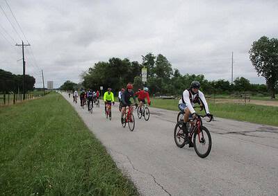 Brightly dressed cyclists riding on a scenic outdoor route, enjoying a group bike ride event.