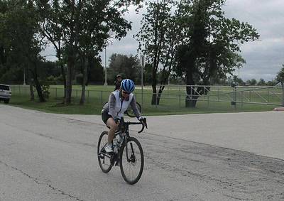 Cyclist riding a bike outdoor on a cloudy day, promoting Bluebonnet Express bike services.