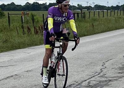Endurance cyclist riding on rural road, promoting Bluebonnet Express bike services.