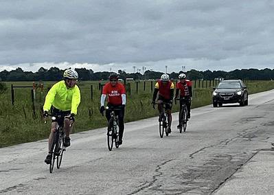 Bright yellow cyclist jacket on a group ride during Bluebonnet Express event in scenic rural Texas.