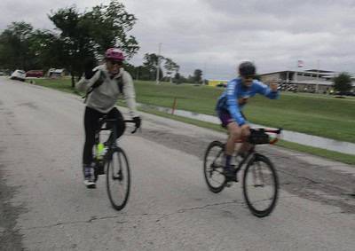 Bike riders enjoying the scenic road on a cloudy day, promoting Bluebonnet Express cycling tours and outdoor adventure.