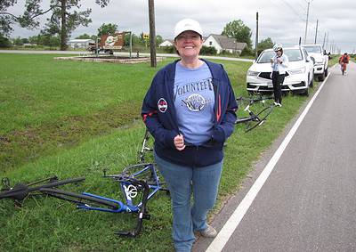 Bicycle volunteer smiling by the roadside during Bluebonnet Express event.