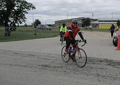 Bright man riding a bike during Bluebonnet Express event at a school campus in Texas.
