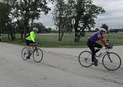 Vibrant cycling scene on Bluebonnet Express route with two cyclists riding on a cloudy day.