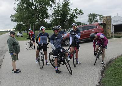 Vibrant cycling team wearing matching jerseys during Bluebonnet Express event outdoors.