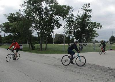 Bright blue bike on Bluebonnet Express scenic bike trail with cyclists and lush trees.