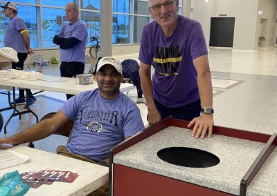 Volunteer smiling at a community event at Waller High School, promoting local engagement and support for youth programs.