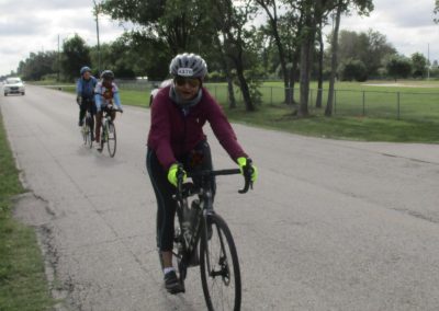 Bright woman cycling on a scenic bike trail in Texas with friends, enjoying outdoor recreation and active lifestyle.