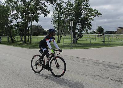 Safe cyclist riding on road during daytime event.
