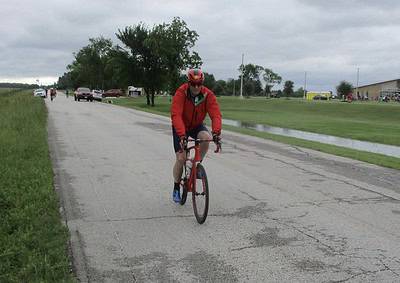 Cyclist riding on a country road during an outdoor biking event.