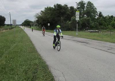 Cyclists riding on a rural road during a daytime bike event for Bluebonnet Express.