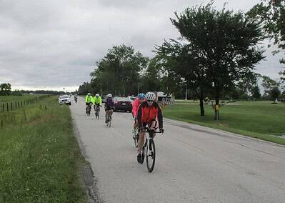 Group of cyclists riding on a rural road, scenic countryside, outdoor cycling adventure, Bluebonnet Express event.