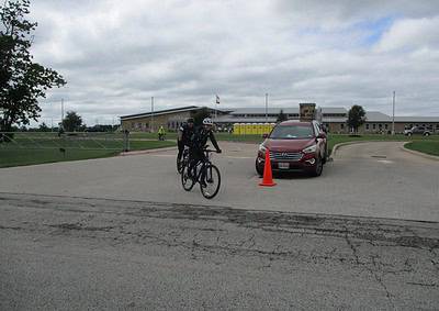 Bicycle riders at Bluebonnet Express, Texas bike route near a community center on a cloudy day.