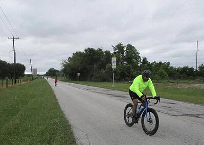 Bright neon cyclist helmet and apparel on a scenic ride along rural roads for Bluebonnet Express cycling event.