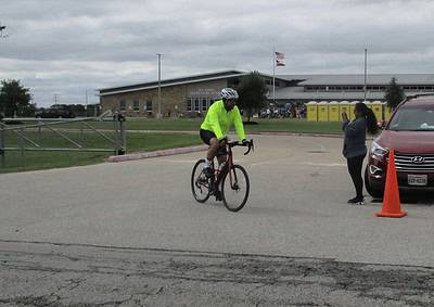 Cyclist in neon jacket riding a bike at Bluebonnet Express event in Texas.