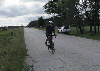 Sunny rural bike ride on Bluebonnet Express route with a cyclist enjoying scenic Texas countryside.