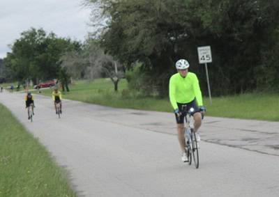 Riders on a scenic road, part of Bluebonnet Express cycling event, promoting active lifestyle and Texas countryside.